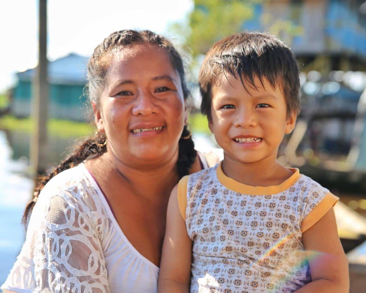 Nadia smiles with her son Pedro, happy that she remembered to dream big dreams thanks to an OBI community health worker program.