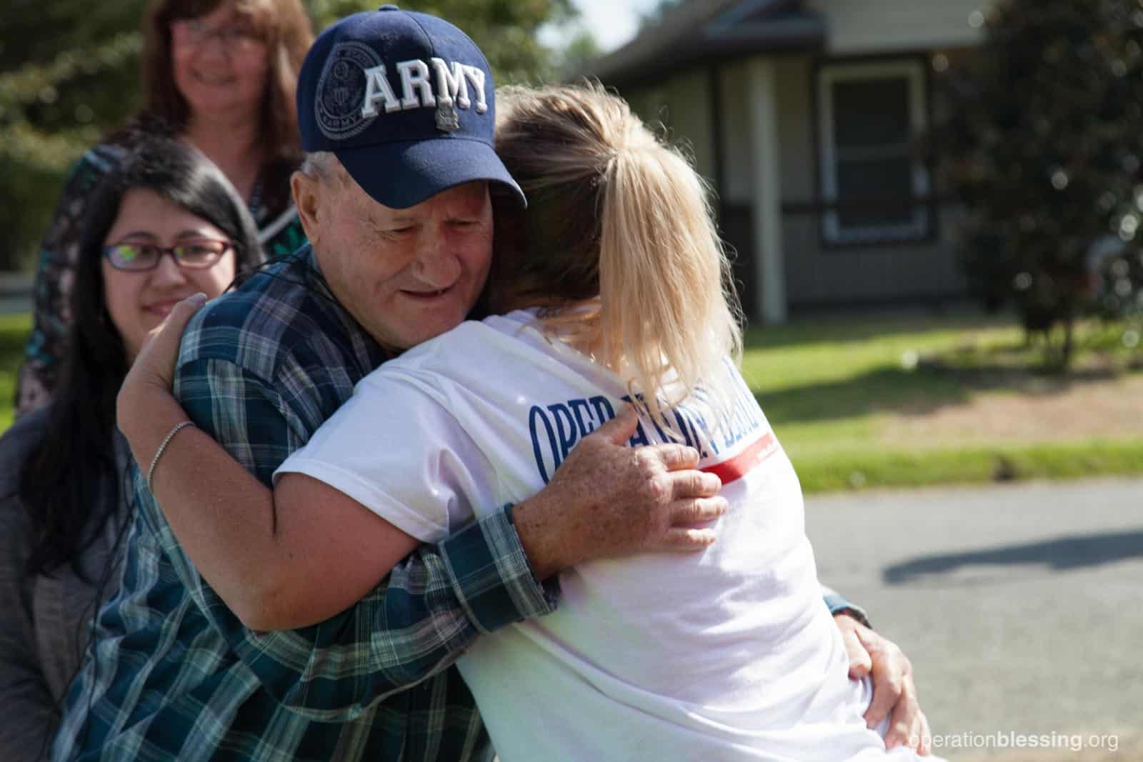 Amy gives Allen, an Operation Blessing beneficiary, a hug.