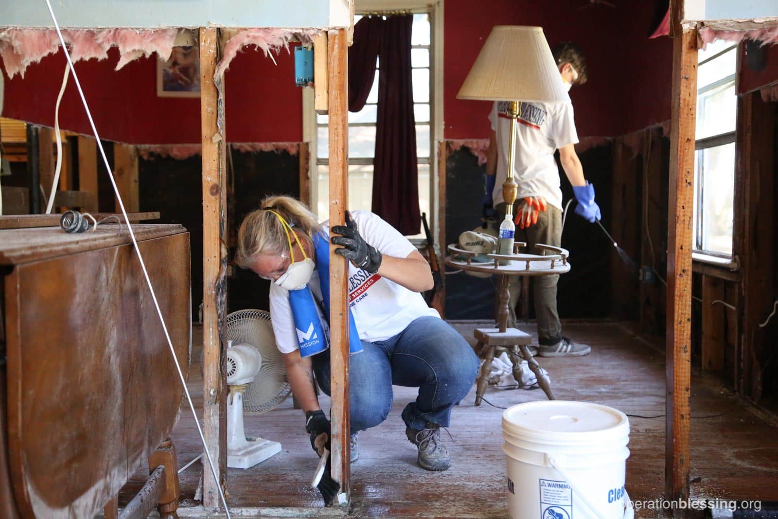 Volunteer Amy hard at work removing rotted and molding dry wall from the home of a Hurricane Harvey victim.