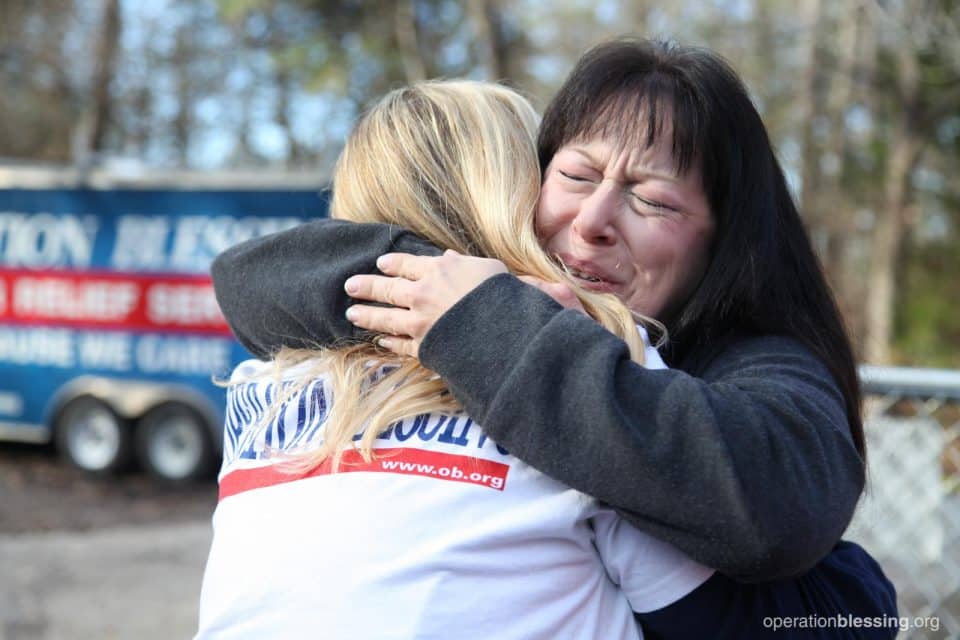 Peggy gives a hug to an Operation Blessing volunteer. 