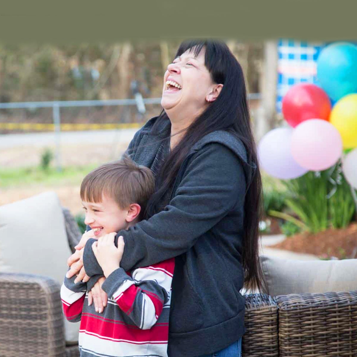 Gabe and his mom, Peggy, laugh outside their restored home.