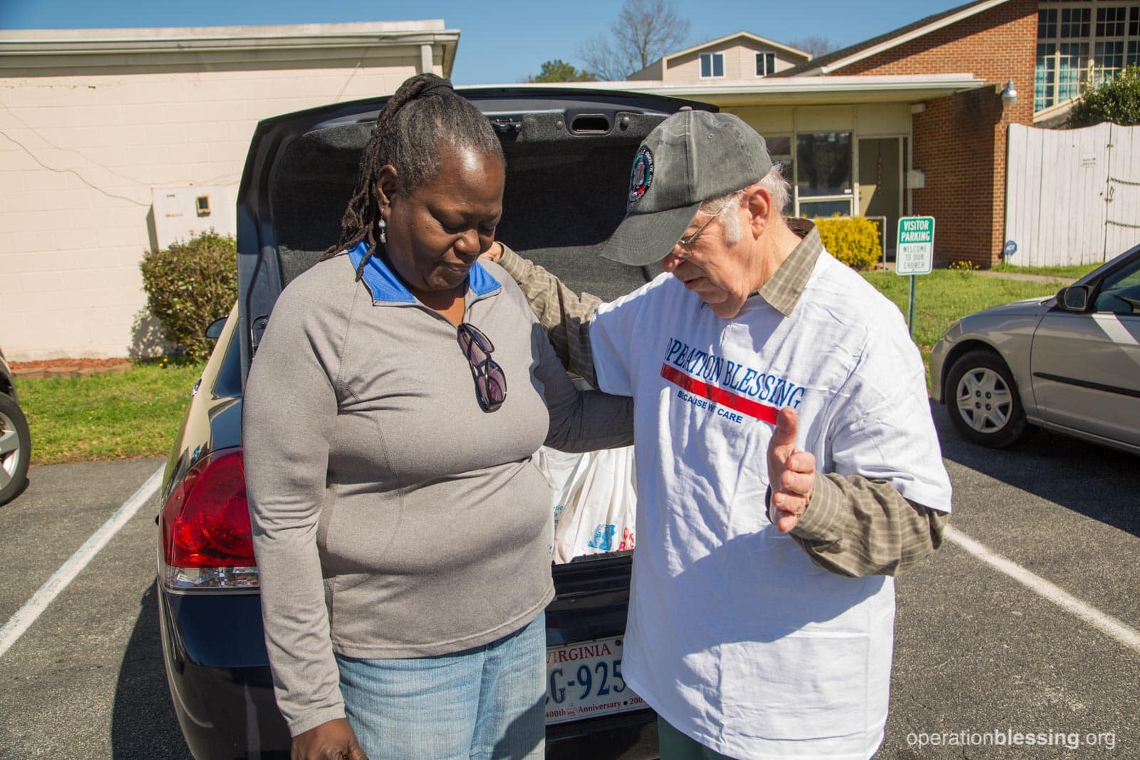 A volunteer prays with Cynthia.