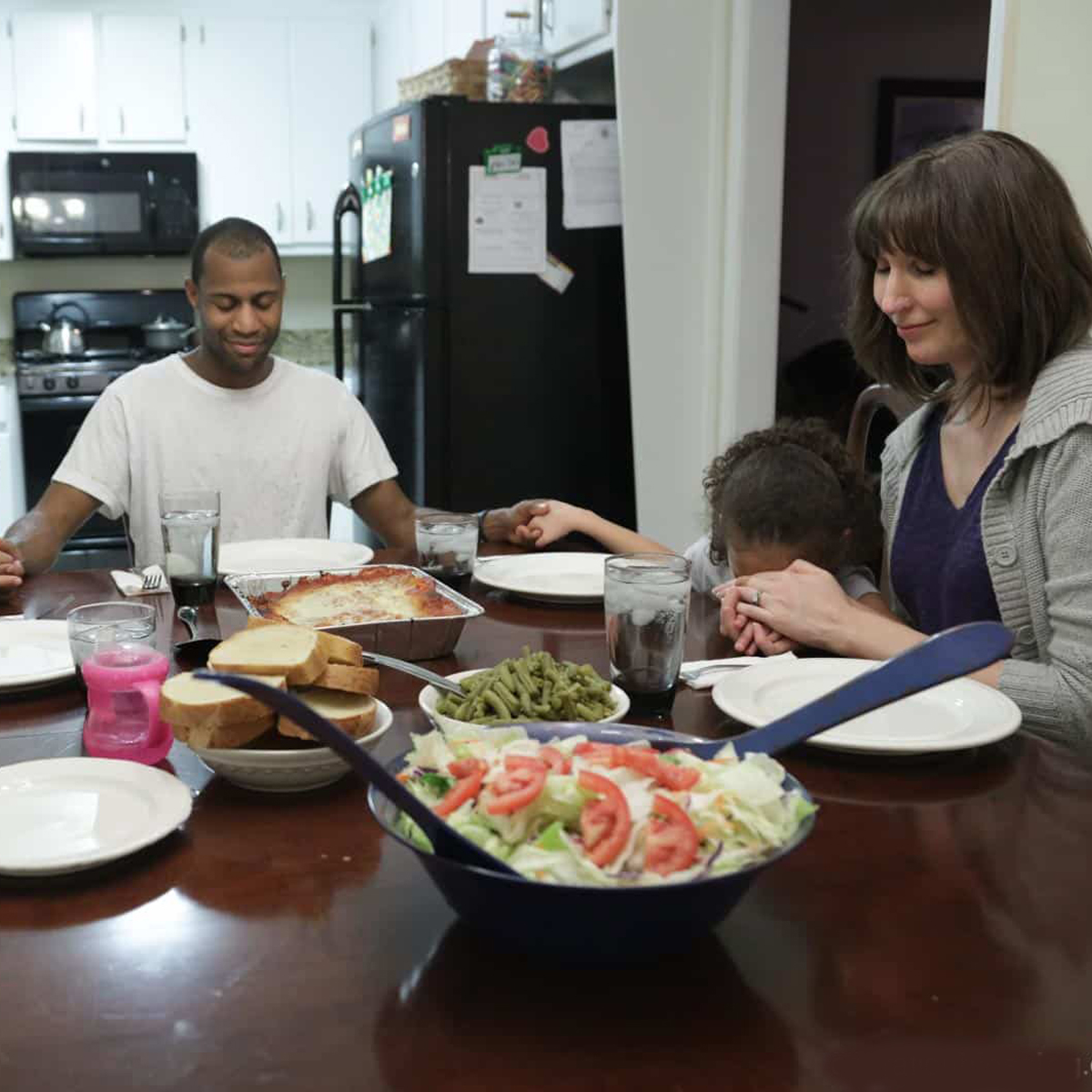 Daniel, Lakashah, and their children, seen here praying over dinner, were in desperate need due to a loss of income and medical bills, until they found Operation Blessing and Warehouse of Hope.