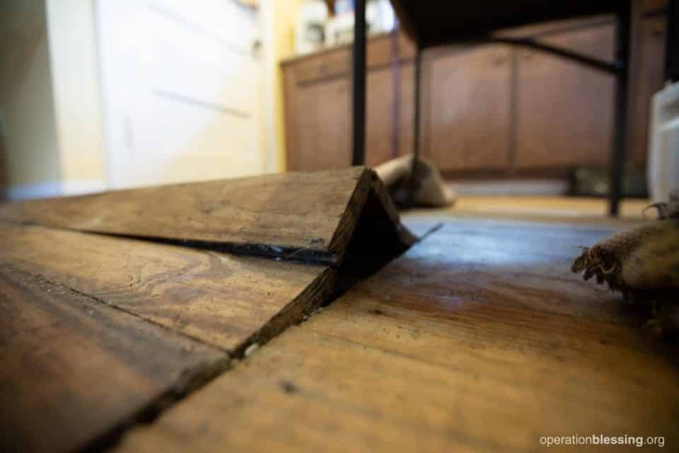 Buckled, water-damaged floors in John and Crystal’s home.