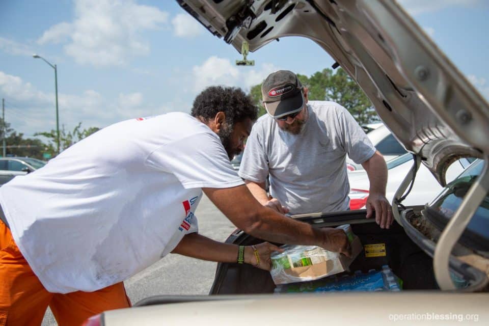 John receiving hurricane relief supplies from Operation Blessing at Without Limits Church.