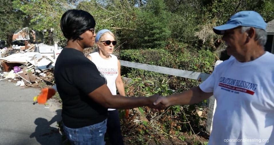 Divya greeting the Operation Blessing disaster relief volunteers who helped with her flood damaged home.