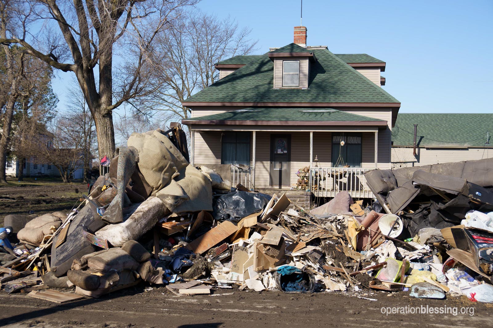 Debris in front of a flooded home in Nebraska