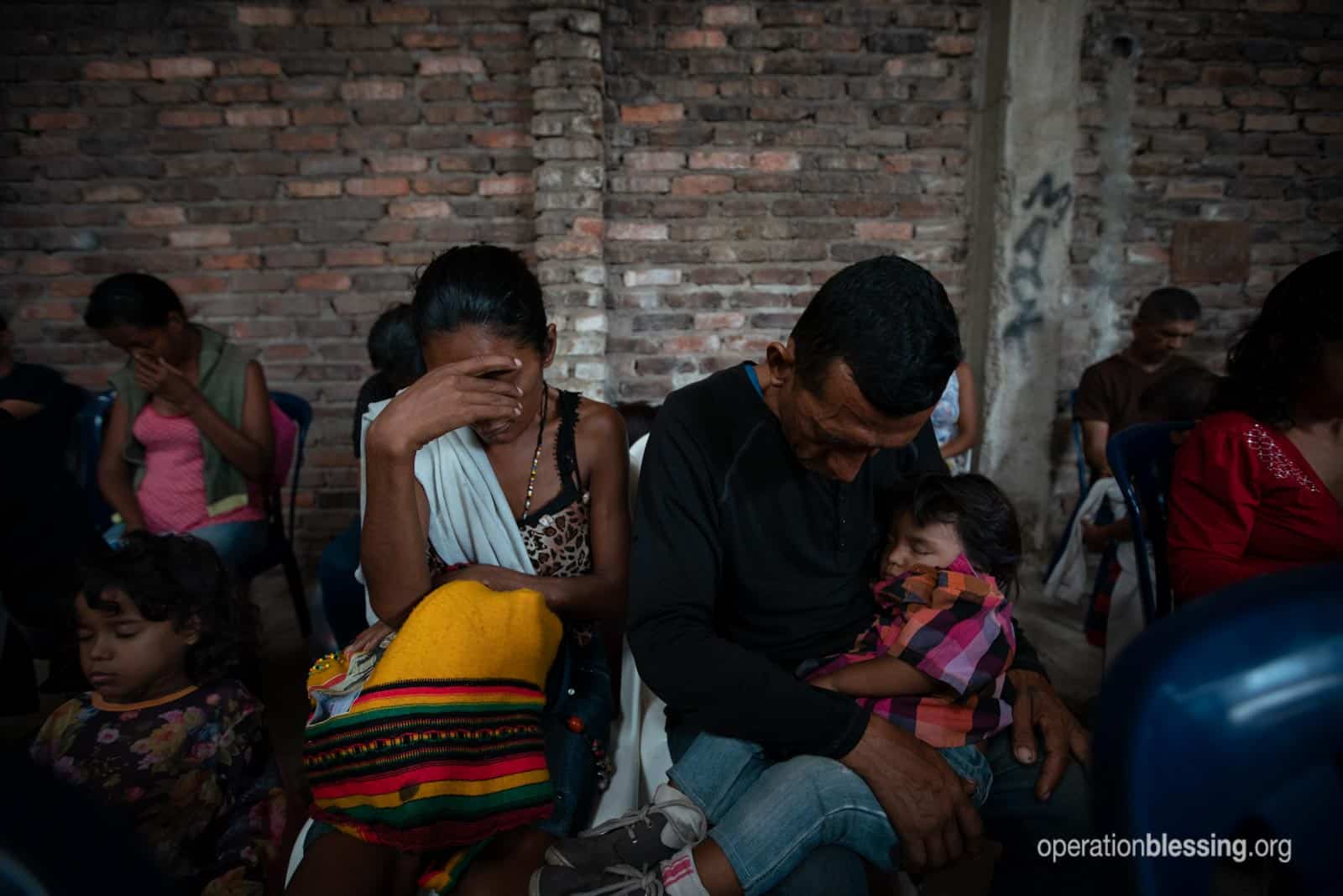 Desperate Venezuelan refugees look exhausted as they hold their child.