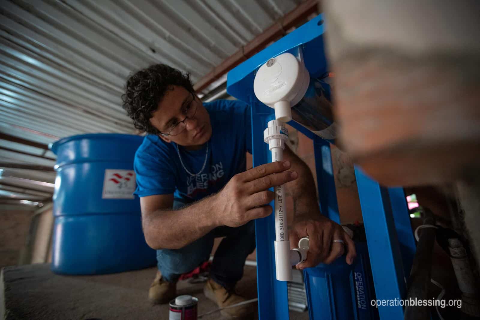 An Operation Blessing worker installs a safe water system for Venezuelan refugees.