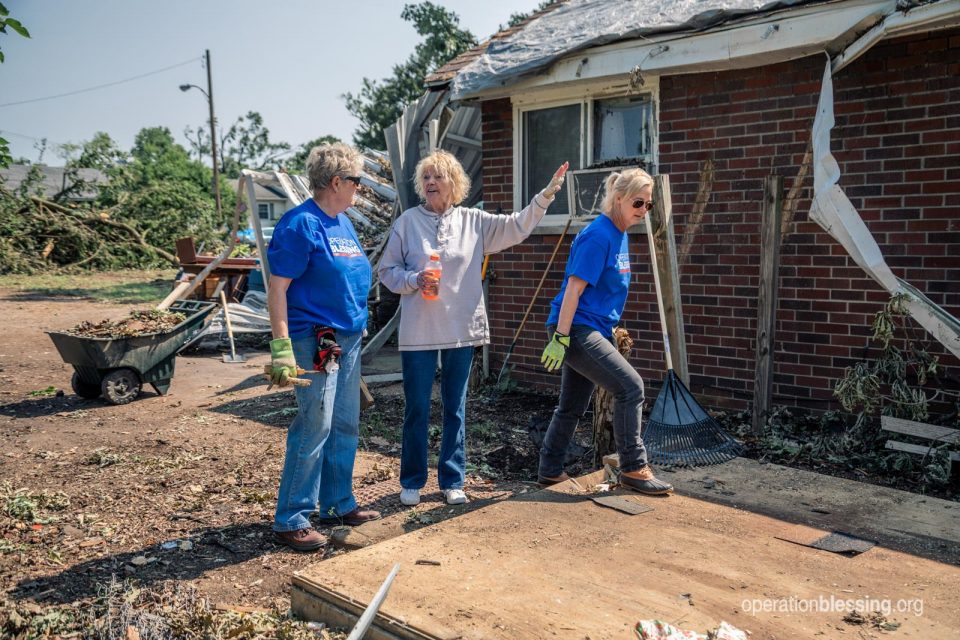 Anita pointing to the damage to her house.