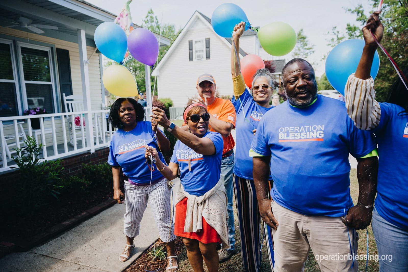 Operation Blessing volunteers greet the family and celebrate their triumph from tragedy.