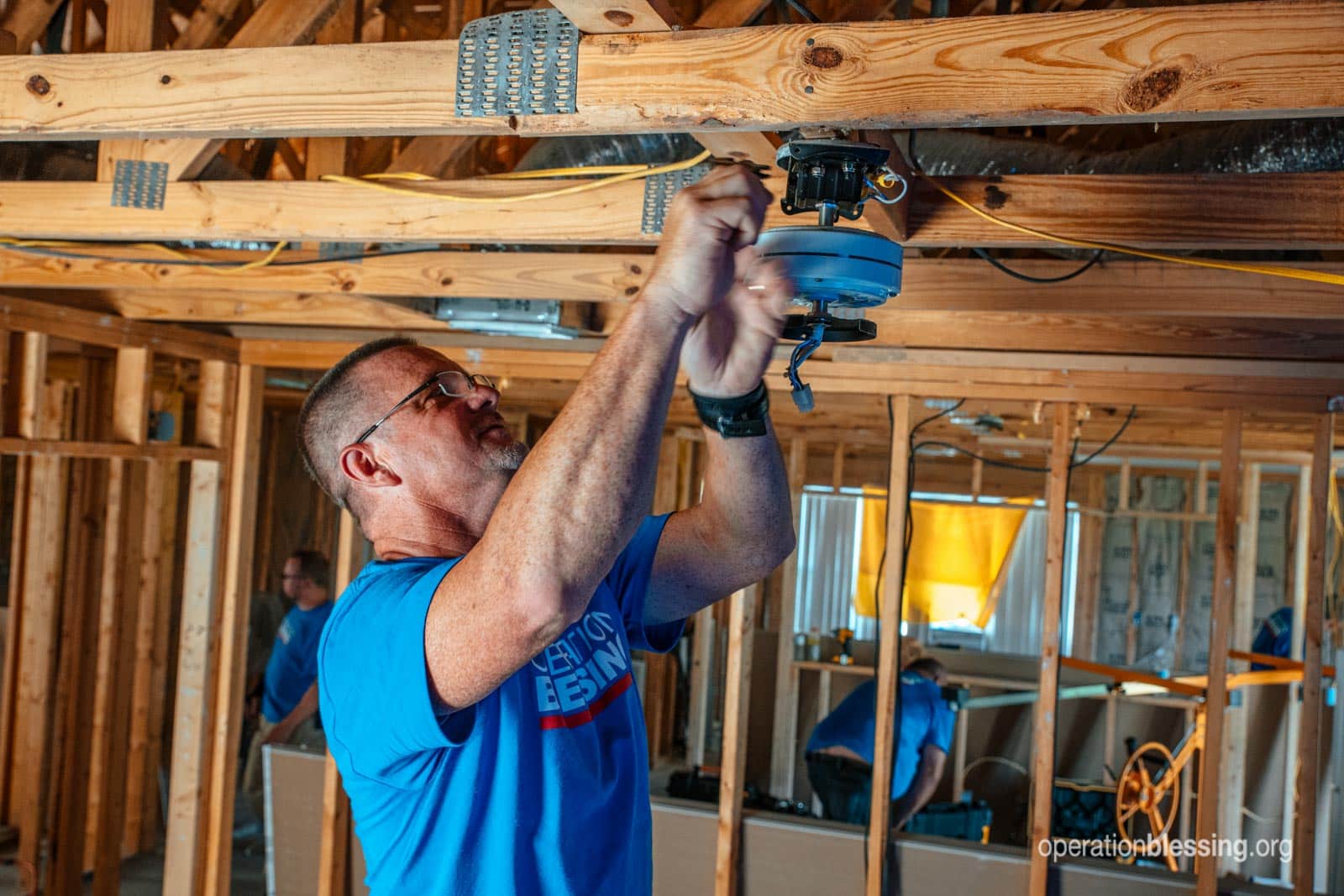 An OB volunteer repairing the Peterson's home.