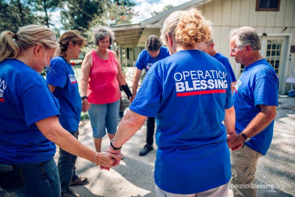 Volunteers pray with Brenda after Imelda in Texas.