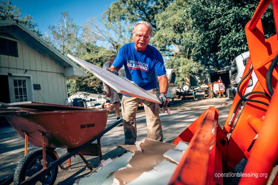 Disaster relief worker carrying debris in Beaumont, Texas.