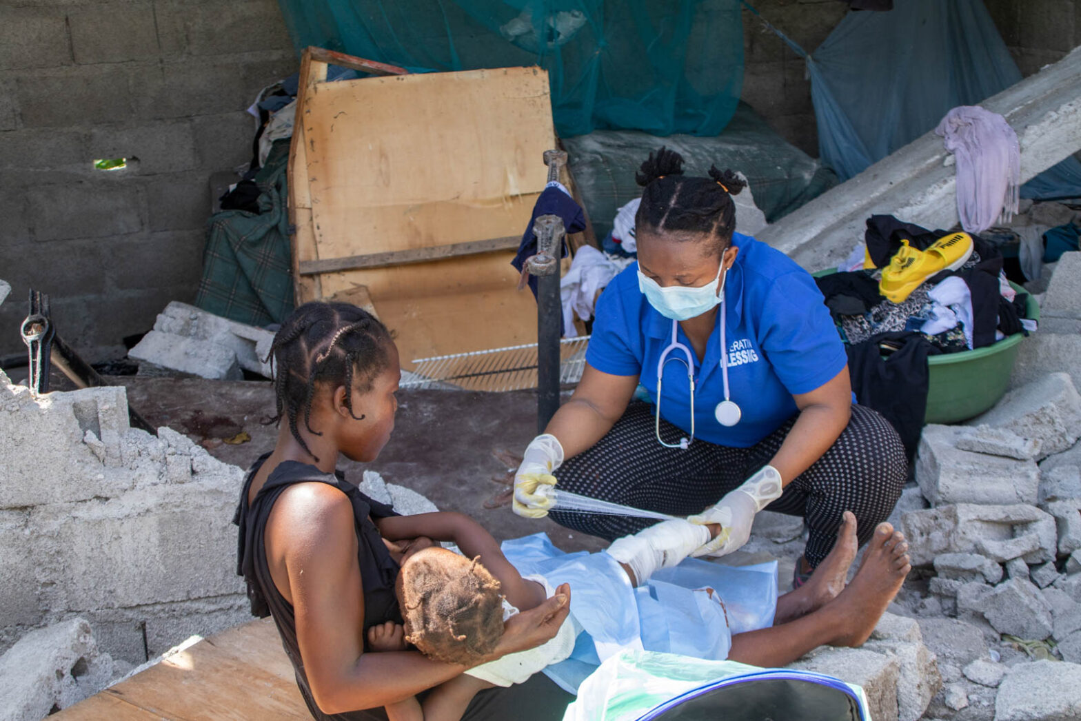 Operation Blessing doctor binds the wounds of a young Haiti quake victim