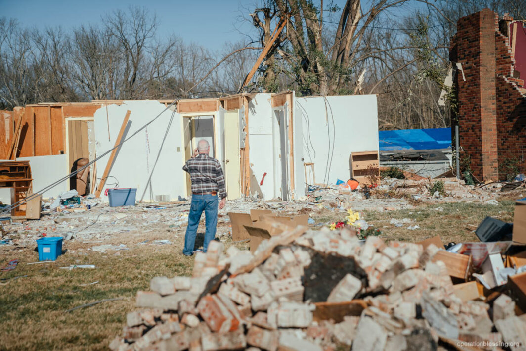 Man looking at tornado damage