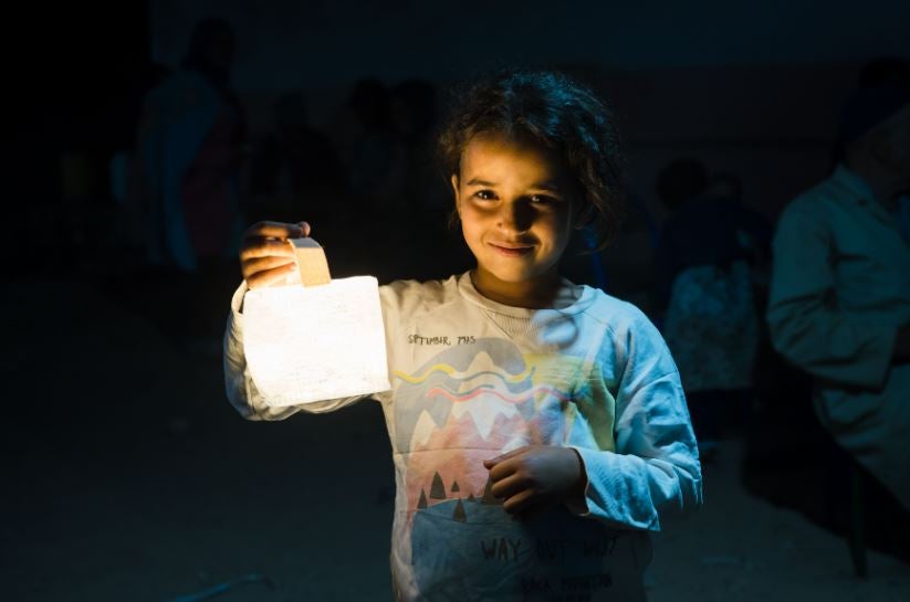 Morocco earthquake aid in action as young victims holds a solar lamp
