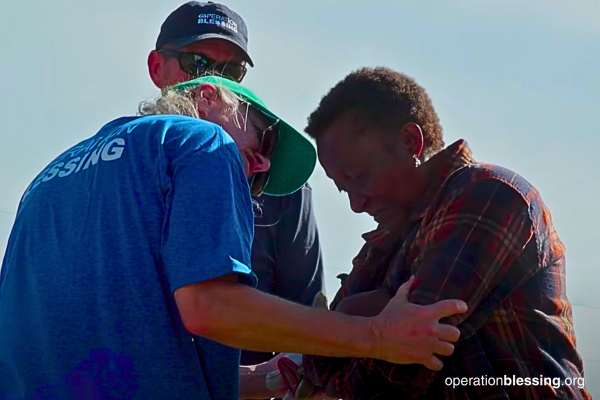 volunteers praying with disaster victims